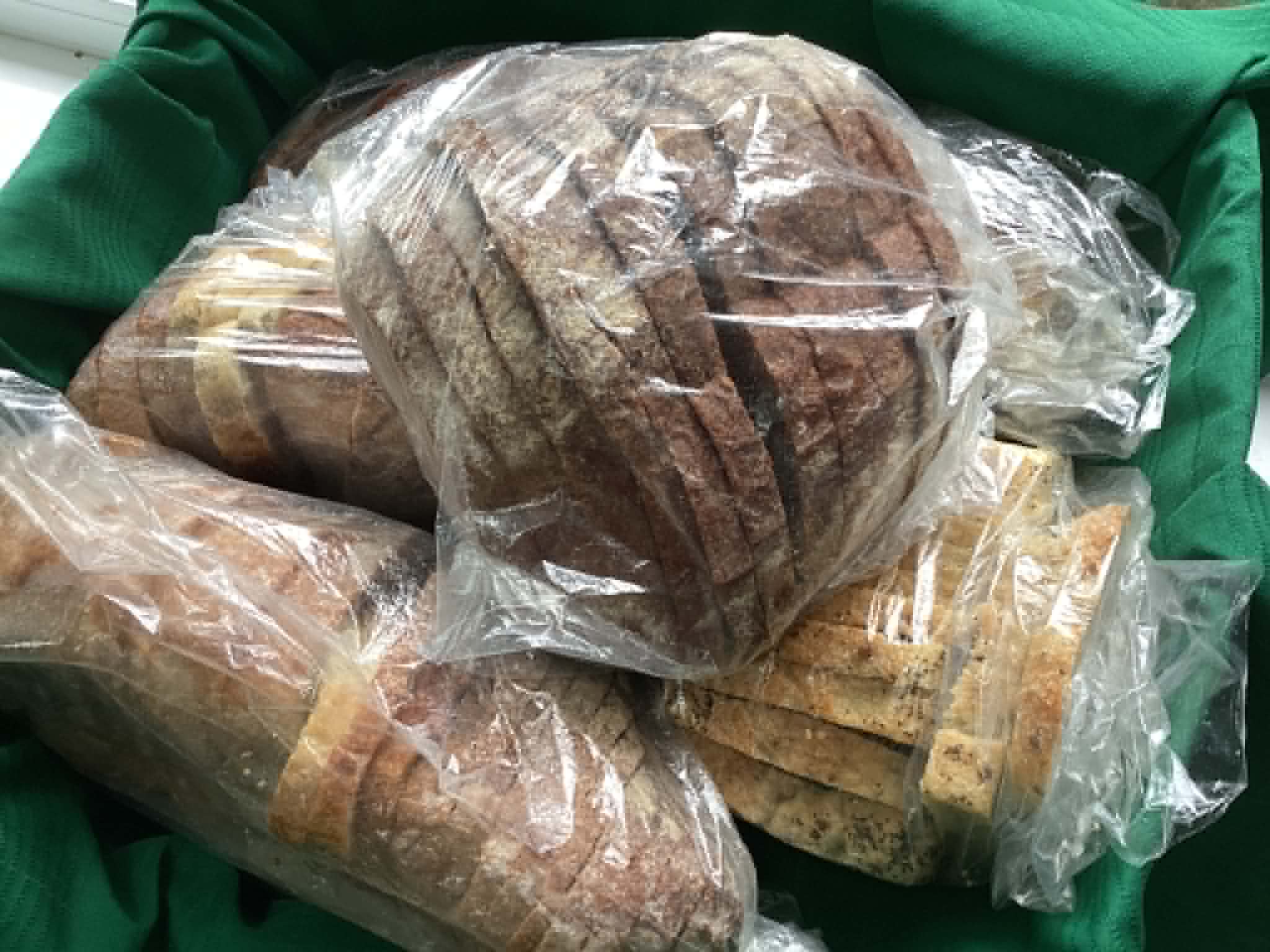 Bagged loaves of donated bread piled in a bin